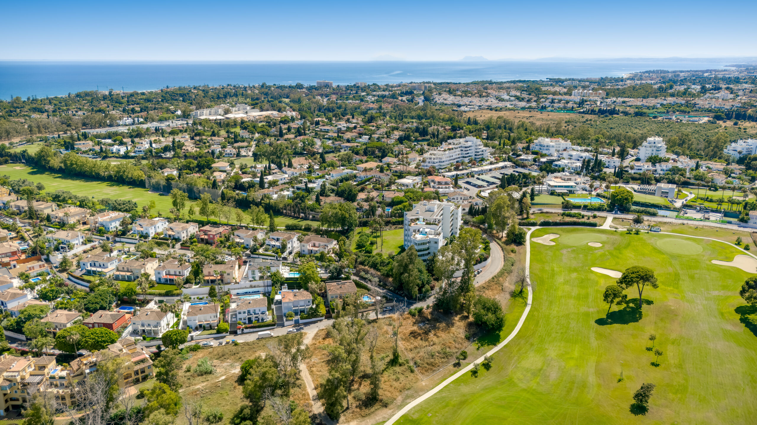Aerial view of a golf course and residential area running down to the Mediterranean
